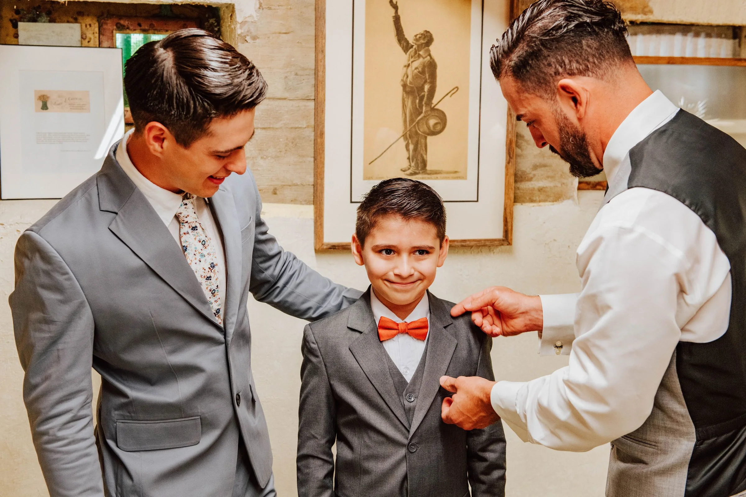 Groom helping a ring bearer get ready